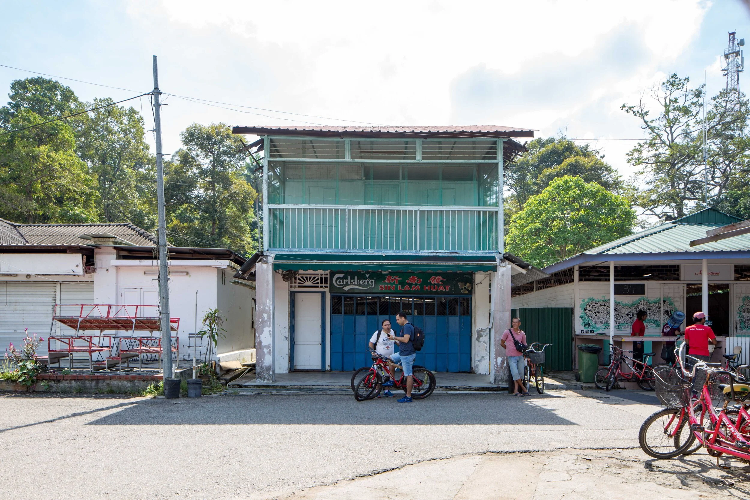 A closed coffee shop and restaurant, with two tourists on rented bikes checking the phone