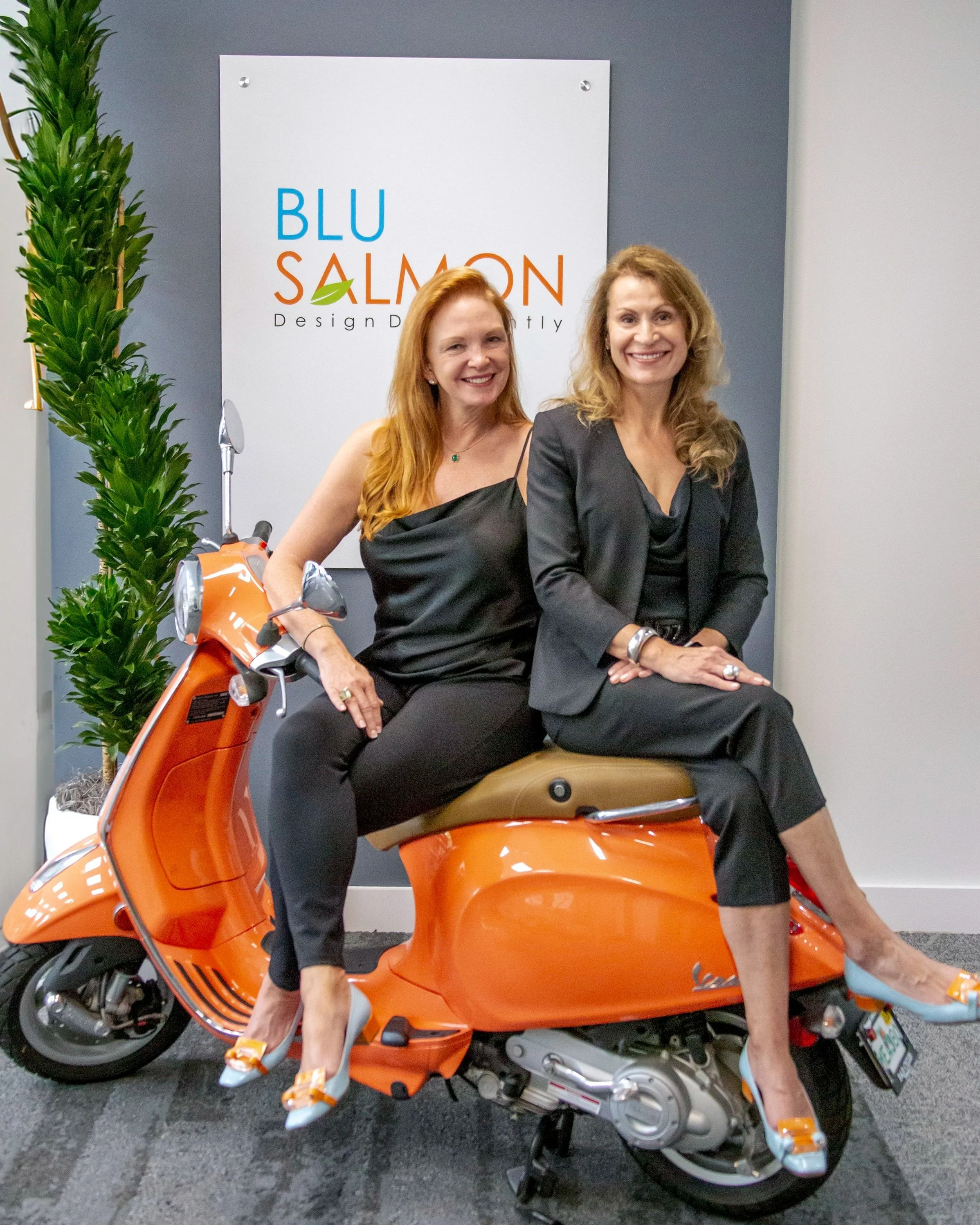Lori Storey and Teresa Dos Santos seating on their famous Vespa.