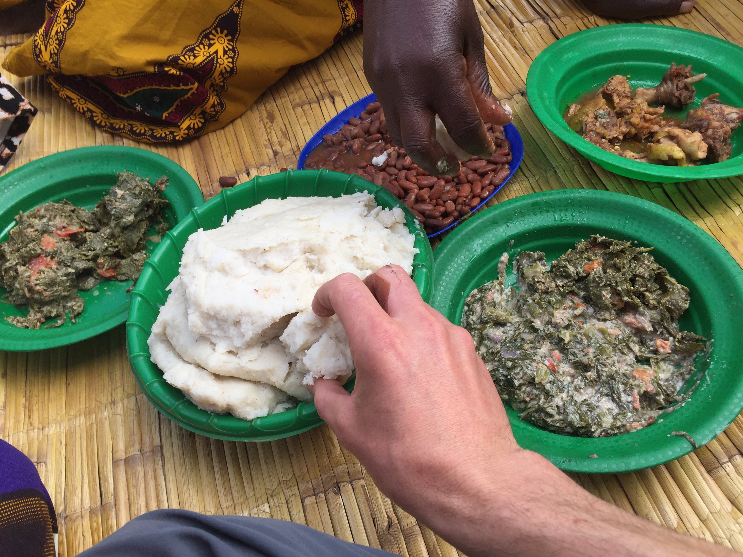  A traditional Malawian meal, eaten by hand out of shared plates. It was delicious, and the chicken in the upper right was walking around when we arrived. The lower right is  Mkhwani , the dish cooked with pumpkin leaves, peanut flour and tomatoes.&n