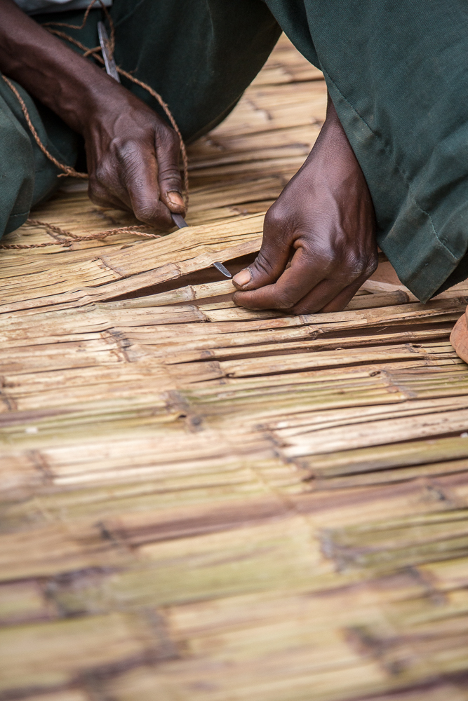  This man was making bamboo mats, which are used as beds. 