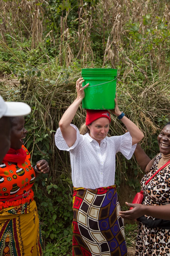 The women of the village wanted Kirsten to try carrying water up the hill. Balancing the water is as much of a challenge as the weight, and many of the women do this without hands, and with children on their backs.