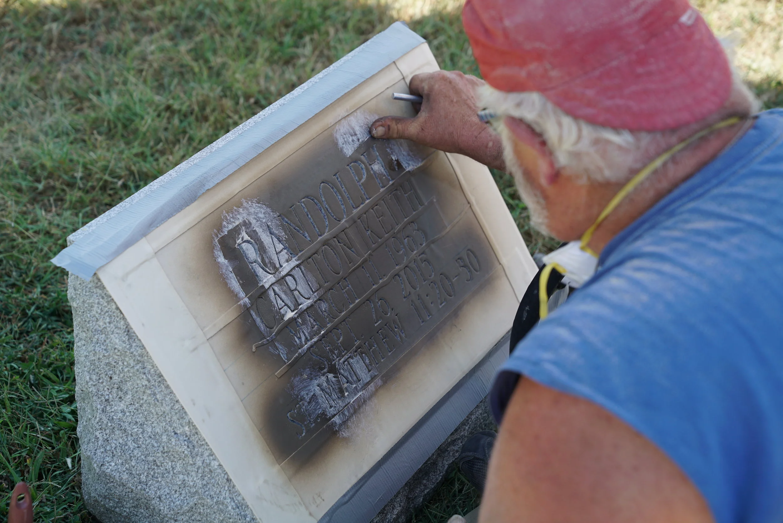 A tradesman doing an inscription job on a slant marker. In metropolitan Philadelphia, expect headstone inscription work to take 90 days. (Not many people do this sort of work.)