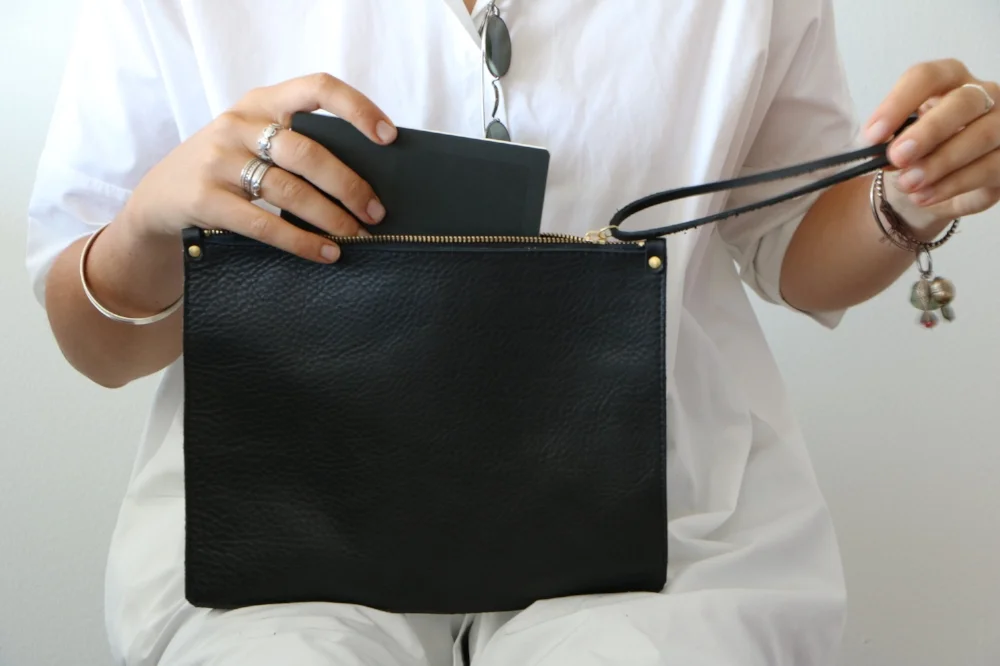 black leather zipped clutch with model