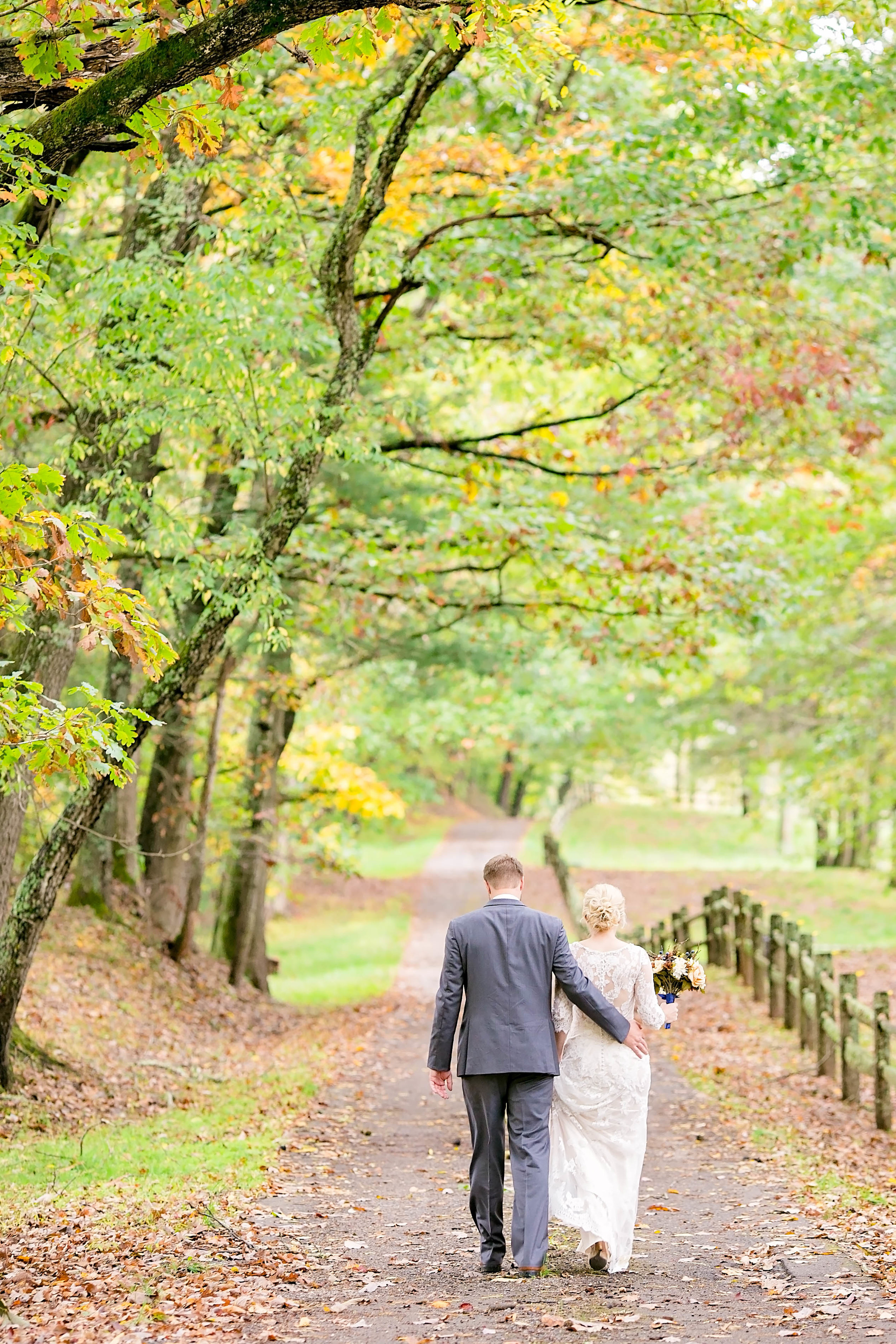 Wedding couple walking on tree-lined path