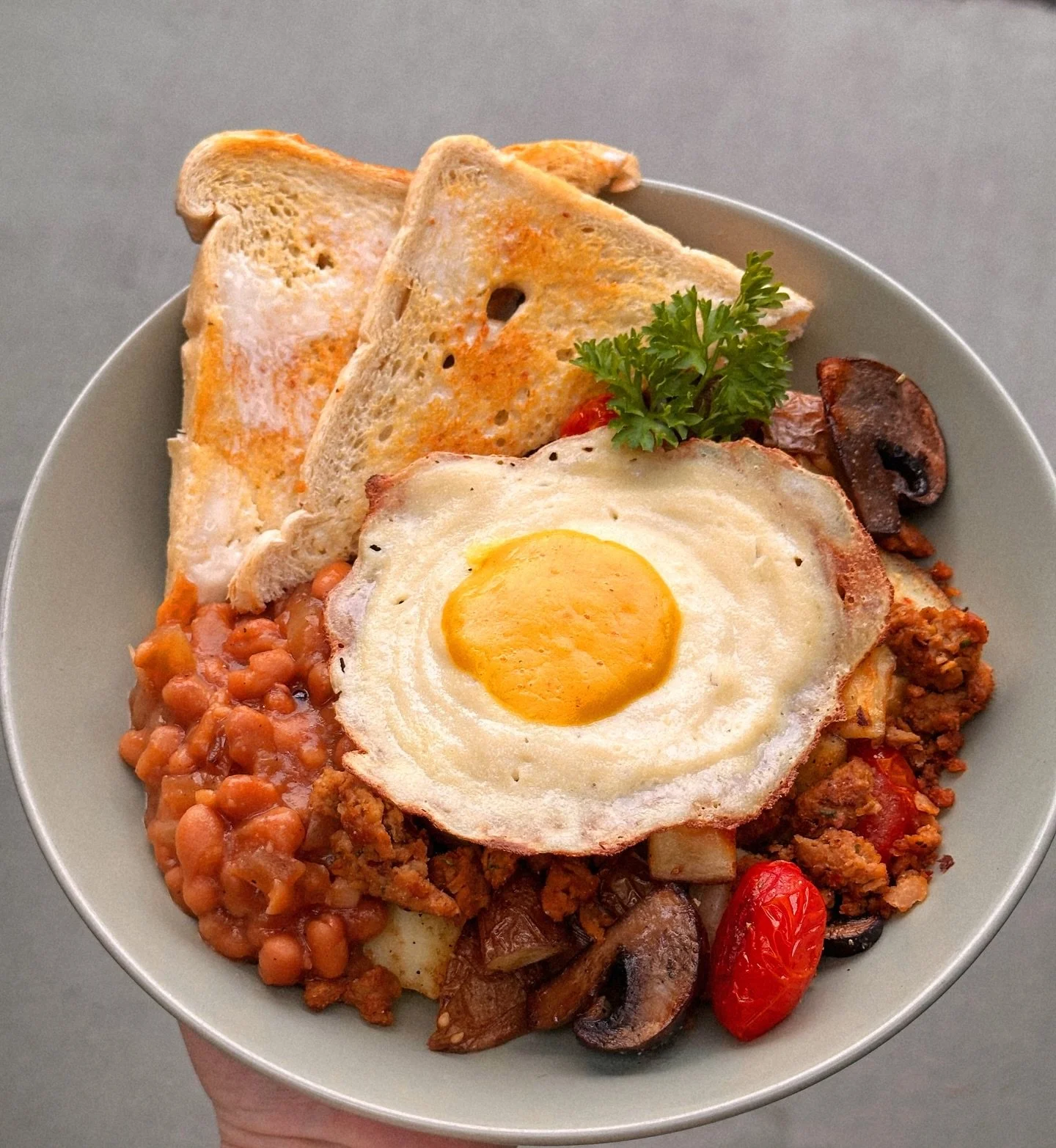 Y&rsquo;all know by now that we love a hash bowl around here. So here&rsquo;s our take on an English breakfast, hash bowl style. Seasoned potatoes, soy mushrooms, roasted tomatoes, crumbled sausage, maple baked beans, buttered toast and a fried egg. 