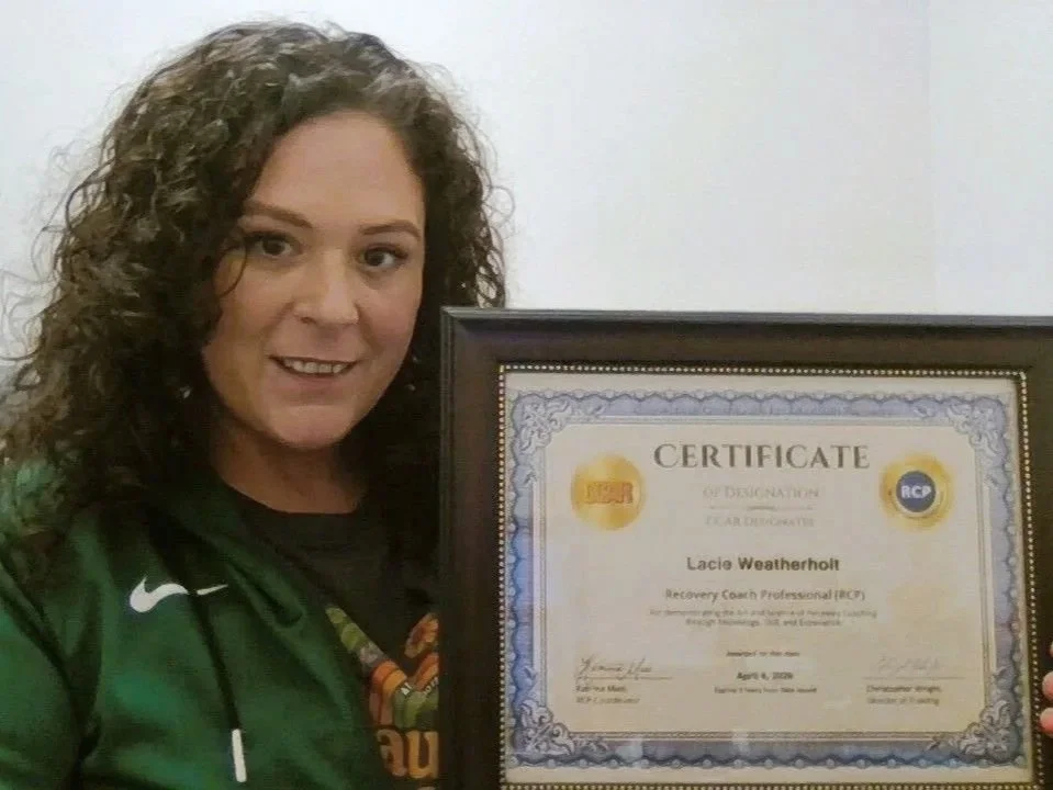 Lacie Weatherholt holding her Recovery Coach Professional certificate after earning her RCP designation through CCAR.