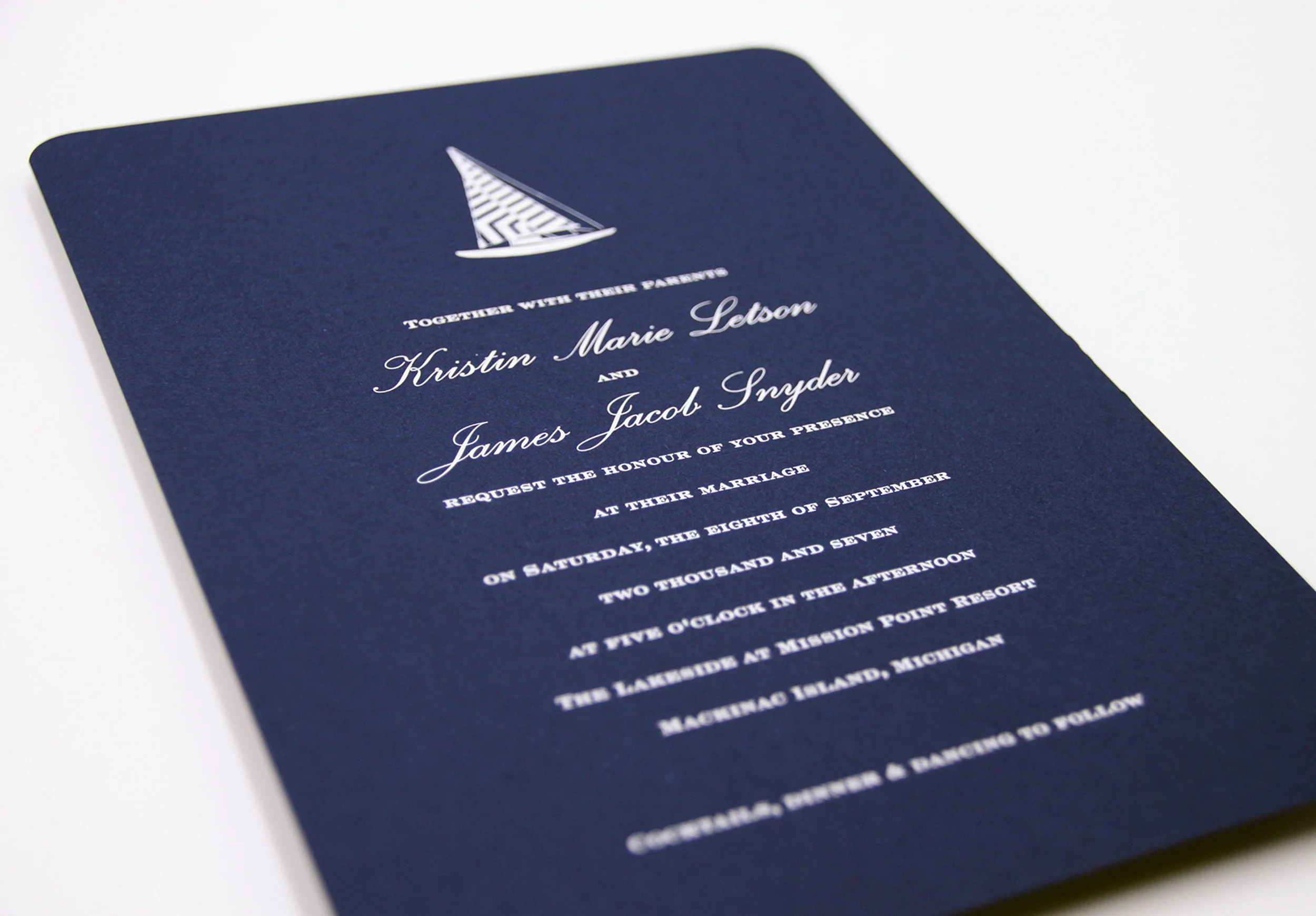 Nautical inspired wedding invitation with custom sailboat motif. Engraved in white ink on navy linen paper. 