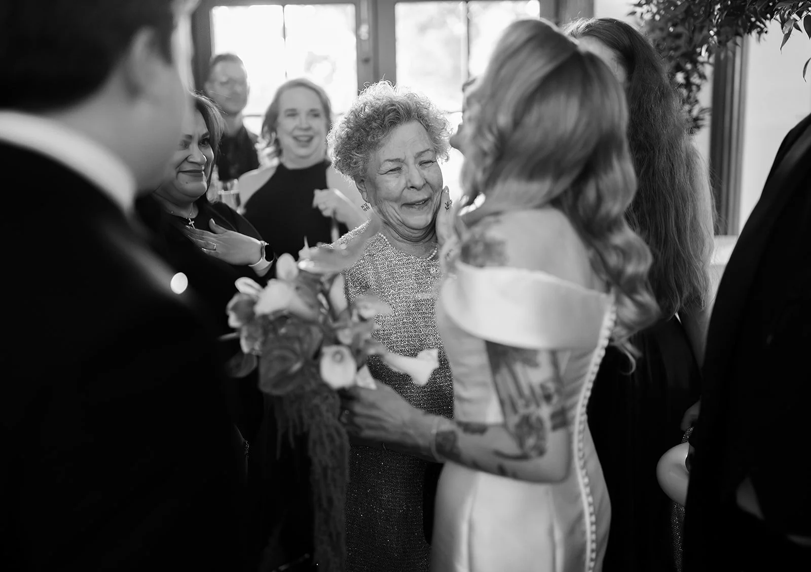 A bride touches the face of one of her guests during an emotional moment after their grand entrance.