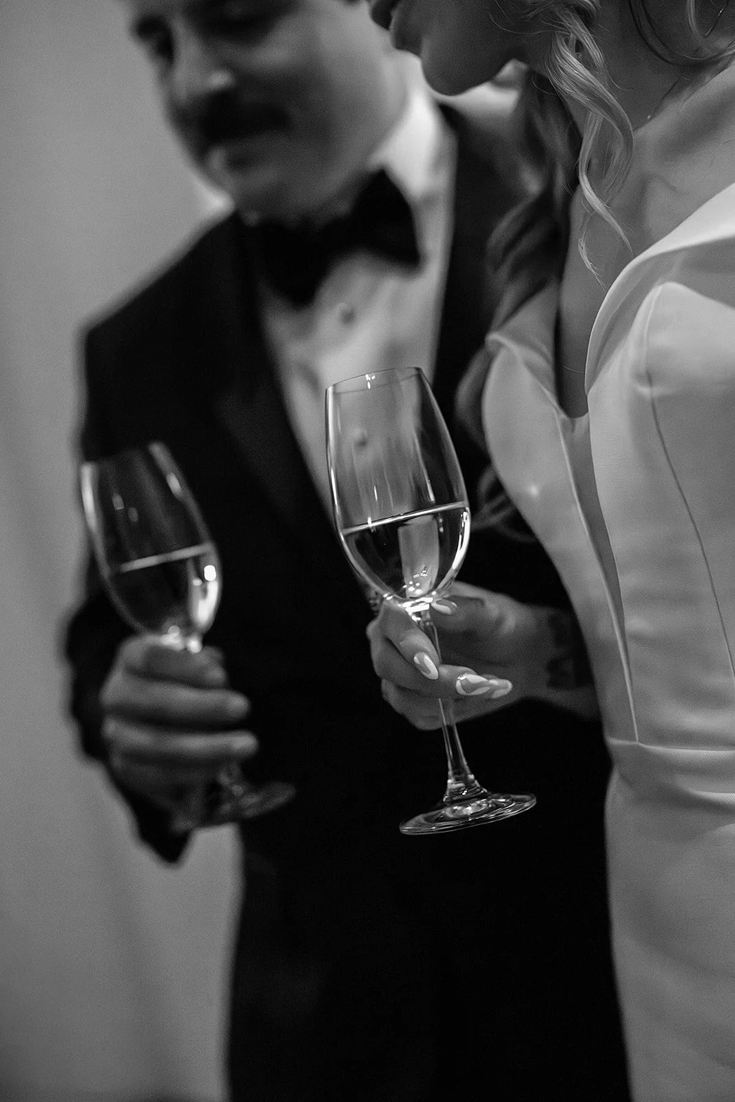 Champagne glasses in the hands of the bride and groom.