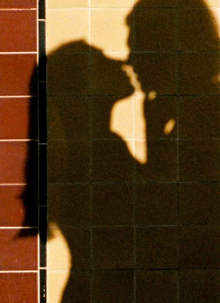 The shadow of a couple kissing projected on a retro wall in a West Texas town.