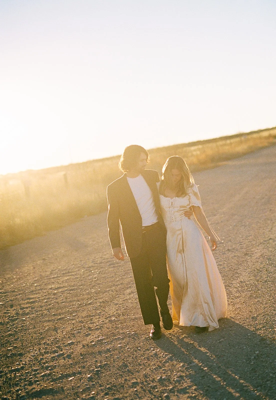 A woman wearing a Mirror Palais dress on a gravel road.