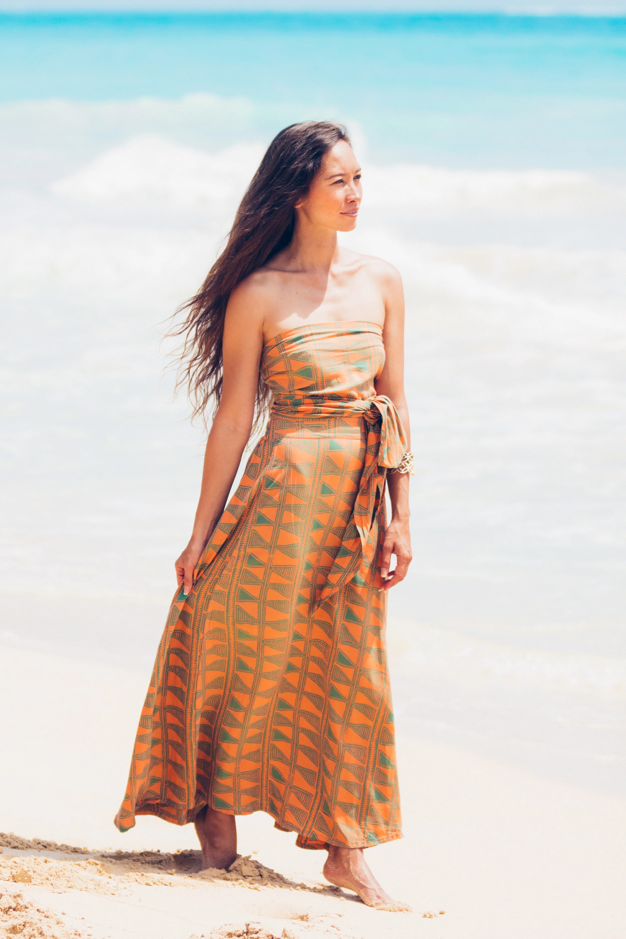 The Sash Skirt is Noa Noa’s best seller. Made of 100% natural fiber rayon, this is a lightweight skirt-to-dress style. The wide sash is attached with an elastic waist for comfort and flexibility. Wear as a skirt with sash tie in front or back, or use sash to create a cute halter dress style. Wear above the bust for shorter dress styles using the sash for multiple tie styles. Perfect little halter dress, strapless dress, sari style dress, or flowing skirt style, this dress can do it all. Comes with a bamboo bangle that can be used as a decorative anchor for sash. Great travel dress with casual or dressy potential. Sizes S-L $159.00 XL $179.00