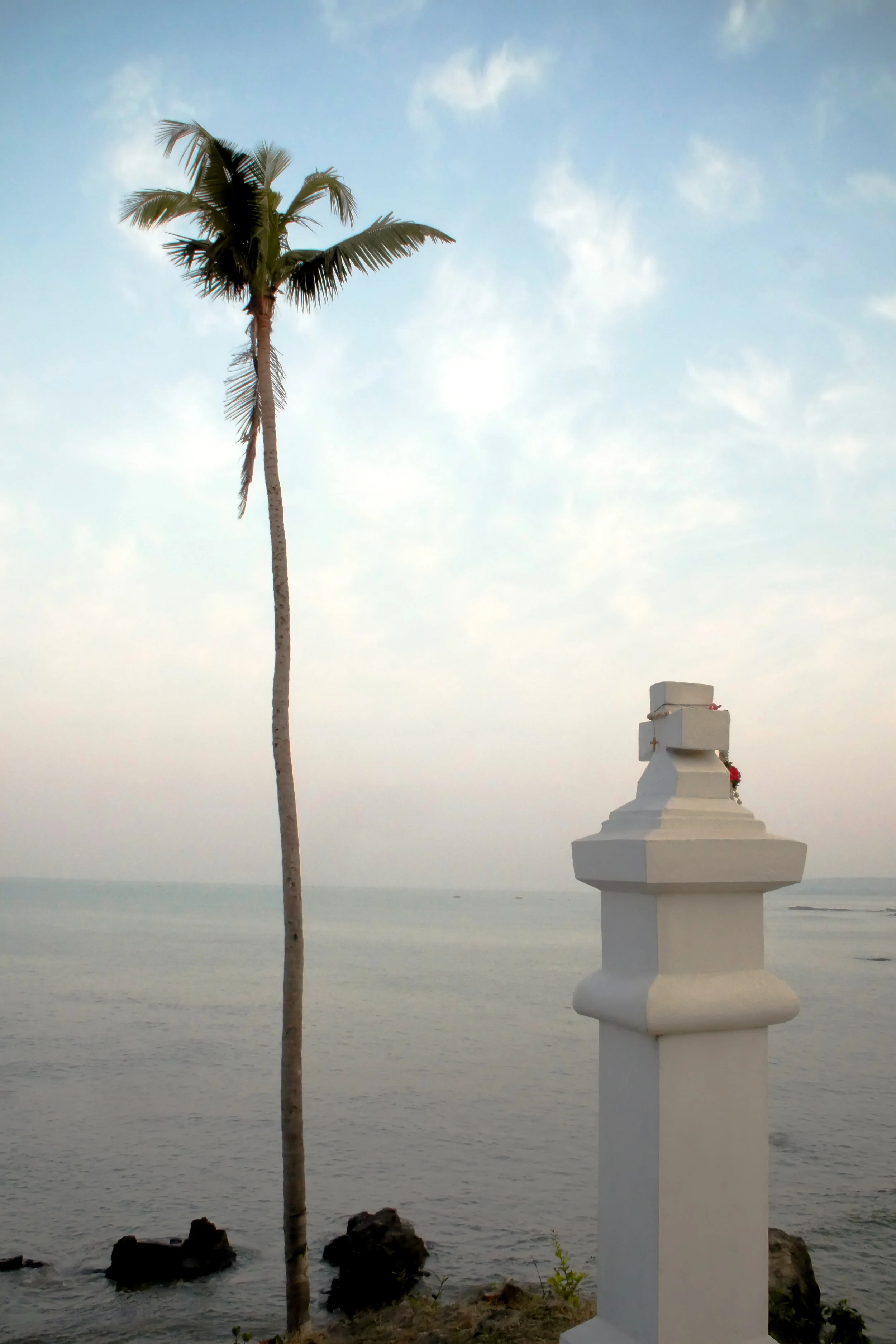 Palm Tree & A Prayer | Vagator Beach | Goa. Nature towers above a manmade cross at the point where Vagator Beach ends and the Arabian Sea continues west for until it reaches it's closest shore; in Oman. The truth which people search for through religion, is always found in nature.
