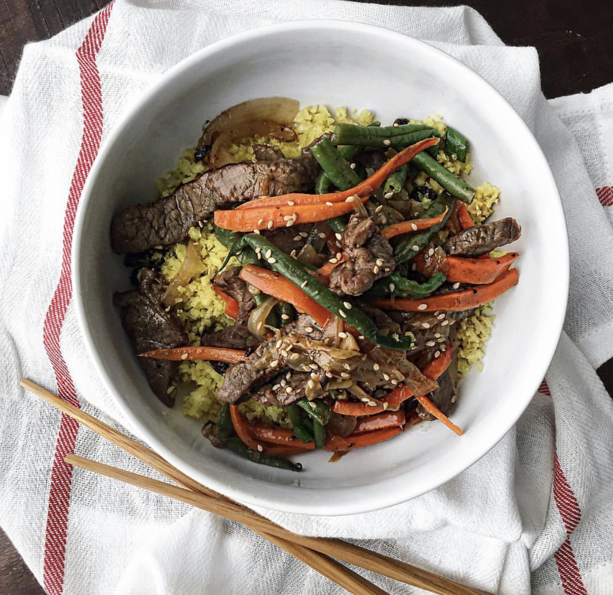 Steps: 1. Season beef w/ salt, pepper and 1/8-1/4c of coconut aminos 2. Coat beef strips with 2tbsp of arrowroot powder (will make meat more tender and moist as it cooks😊) Allow to marinate 30-60mins. 3. Stir fry beef in batches so as not to overcrowd pan till brown on all sides. Remove to a pan. 4. In the same skillet/wok add oil. Once hot, lightly sauté garlic, ginger and tangerine zest till fragrant bout 30secs . Toss in onions sauté about 2mins then add carrots and string beans for another 2-3mins. You can steam carrots and string beans first if you prefer less crunch to your veggies. 5. Return beef to pan and toss well. 6. Add tangerine juice and the remaining coconut aminos. Toss well to mix 7. Sprinkle with sesame seeds and enjoy! Serve with cauliflower rice.