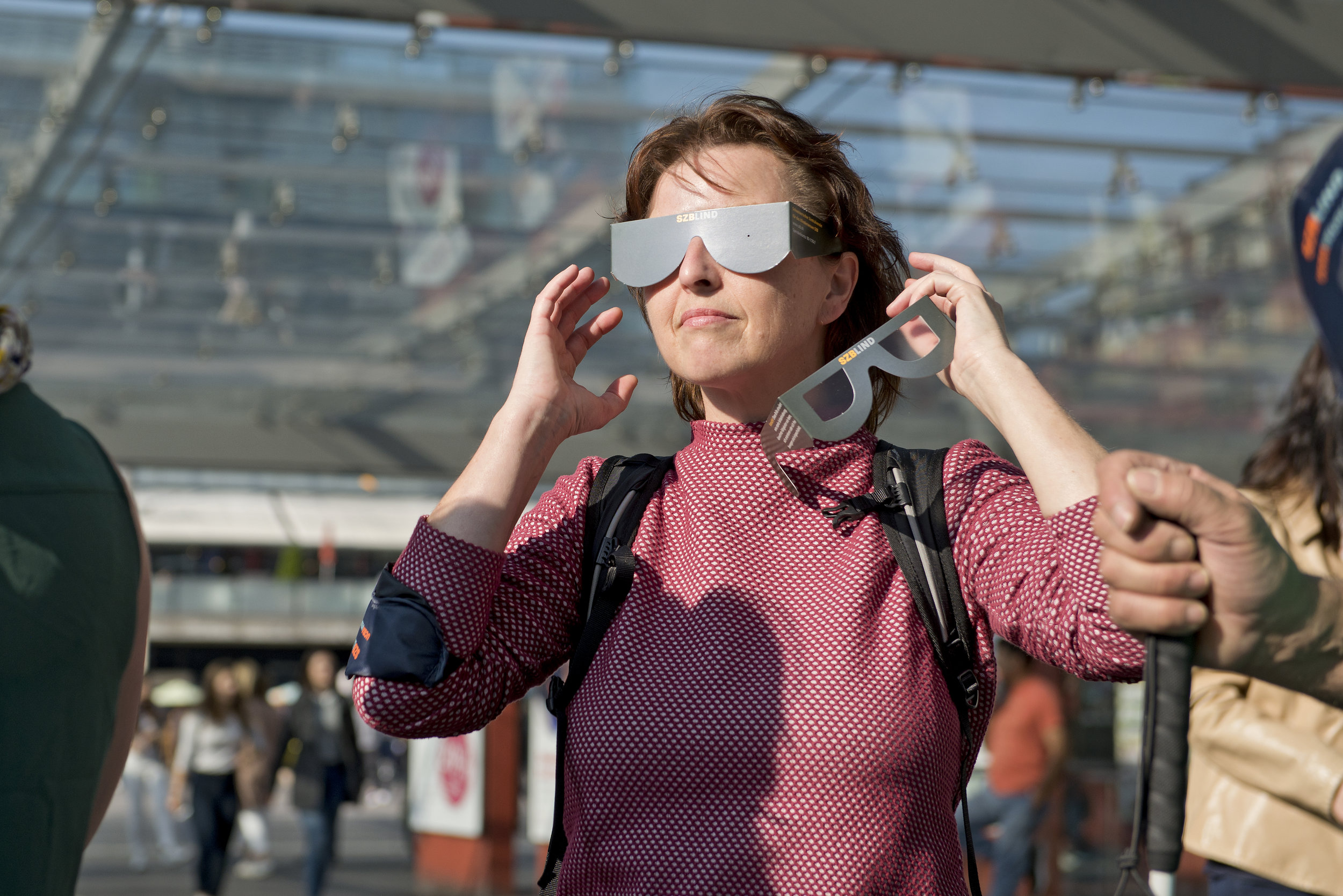 Eine Frau mit Simulationsbrille versucht, in der Ferne etwas zu erkennen.