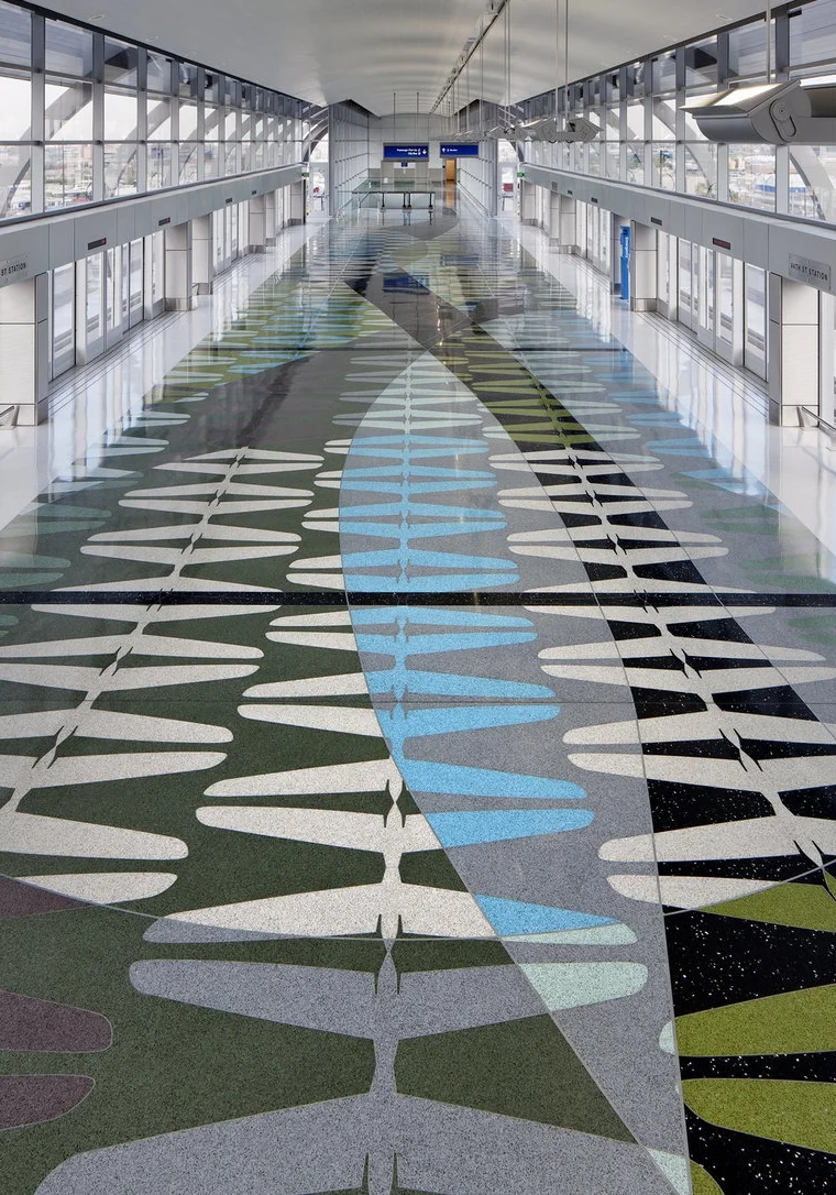 Phoenix Sky Harbor Airport Train Station / Phoenix Arizona The floor is inspired by the outline of an airplane’s horizontal stabilizer, known as a tailplane. Fernandez used ten colors to create the platform’s rhythmic geometric patterns and sweeping bands. He heightened the floor’s reflective qualities by adding aggregates of recycled, crushed glass and mirror.