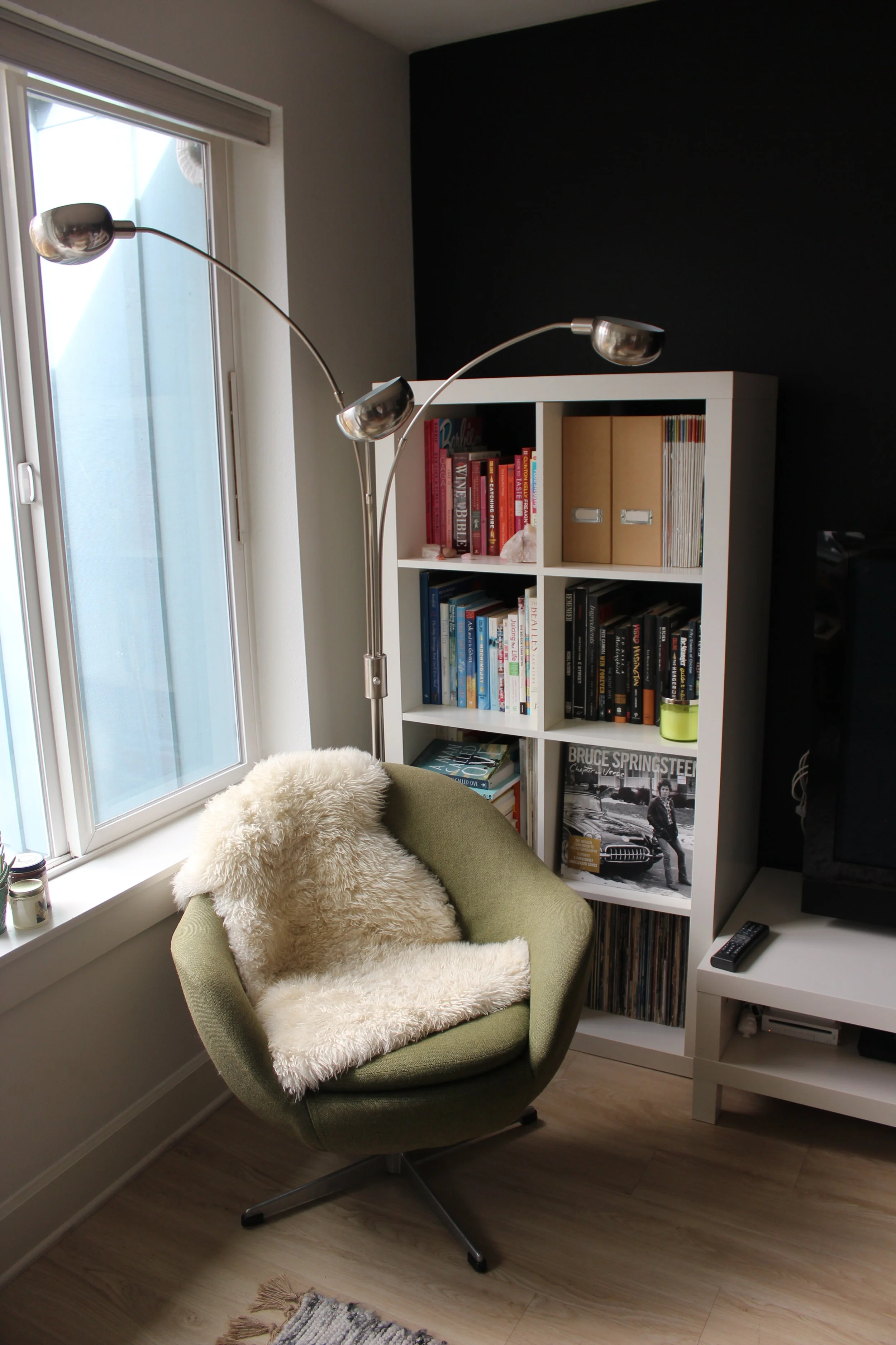 BEFORE: The love and relationship corner of the living room felt heavy with the rectangular bookshelf blocking the corner, and a lamp that felt out of place. Overall, the space was lacking softness, plants, and intention.