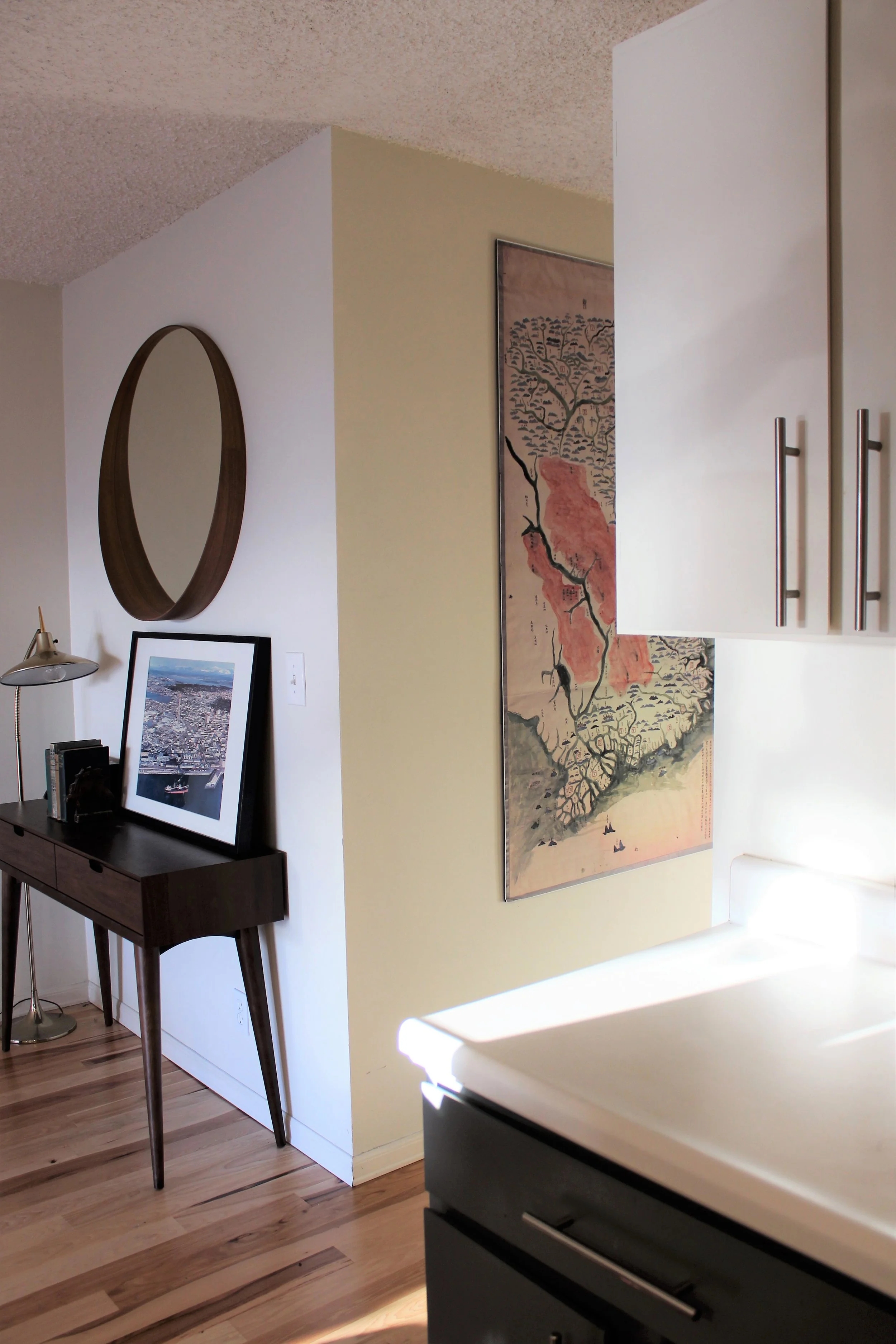 We replaced the existing carpet with new hardwood floors and for a low budget upgrade, we painted the kitchen cabinets (gray lower cabinets and white upper cabinets) then added new hardware for an updated look. 