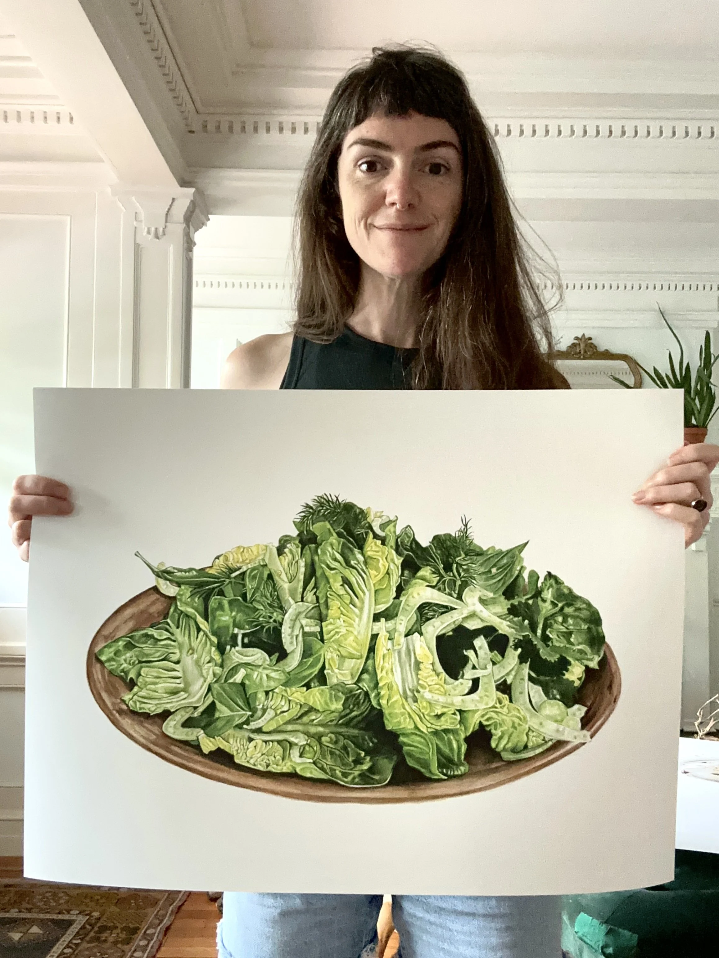 Person holding a large poster of a bowl of assorted green leafy vegetables.