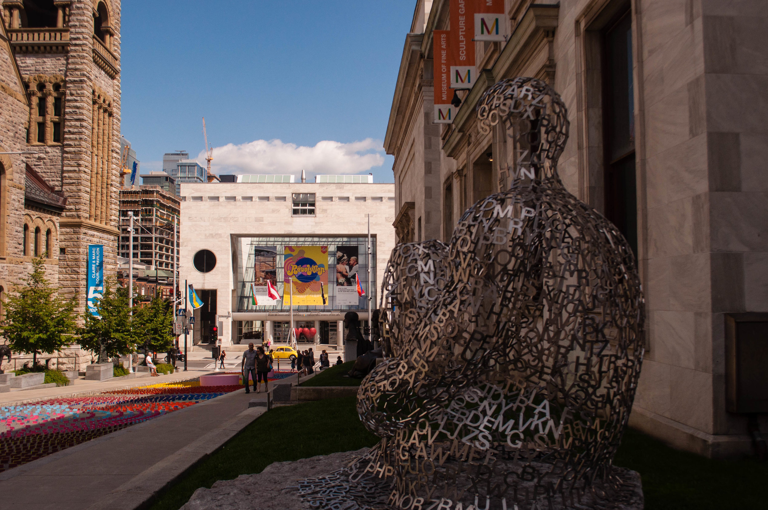 Quartier du musee alley in Montreal with the Fine art museum in the background and a sculpture in the foreground