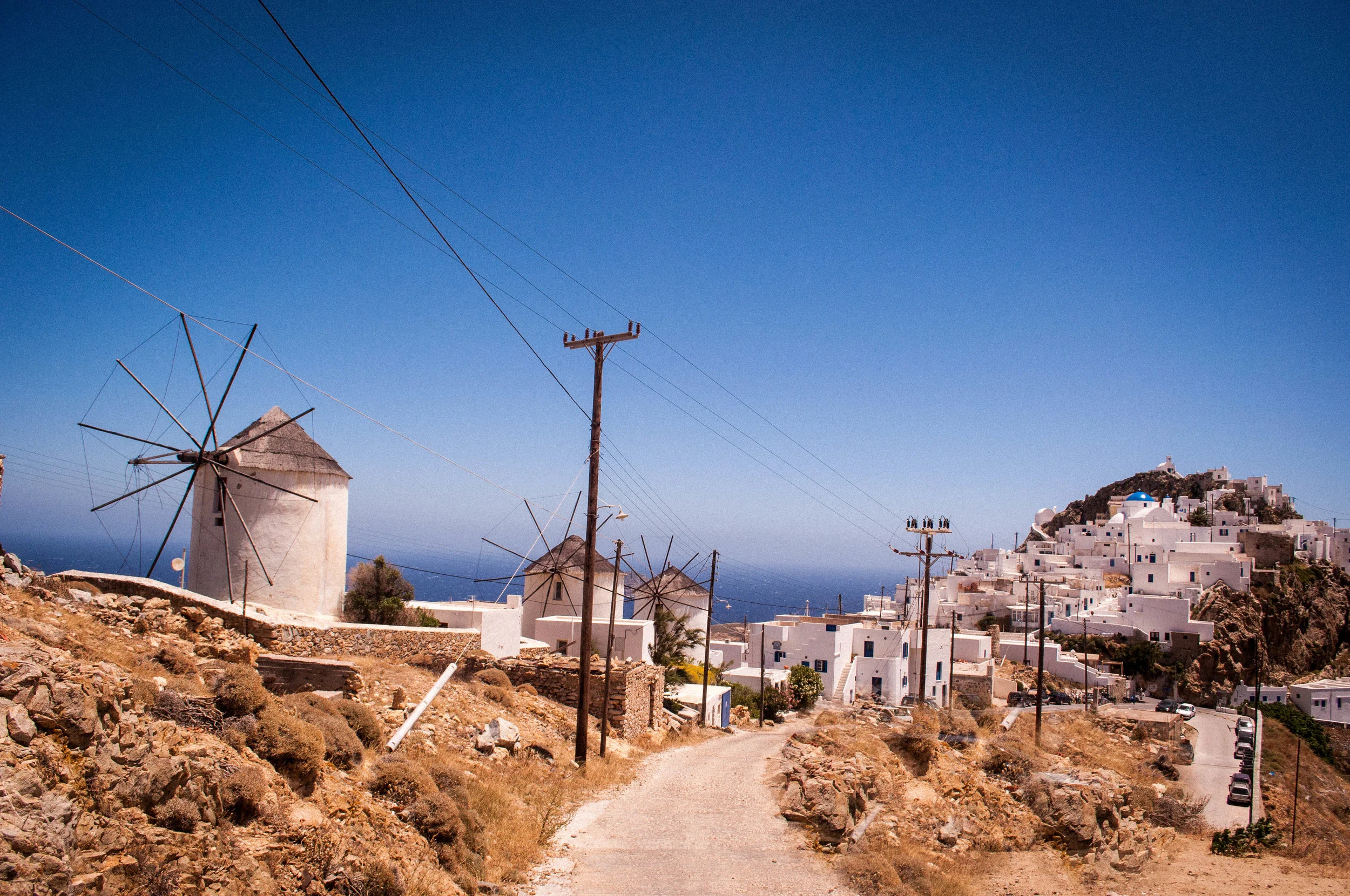 Image of the island of Serifos with its traditional architecture of white buildings and blue dome roofs on the churches and wind mills