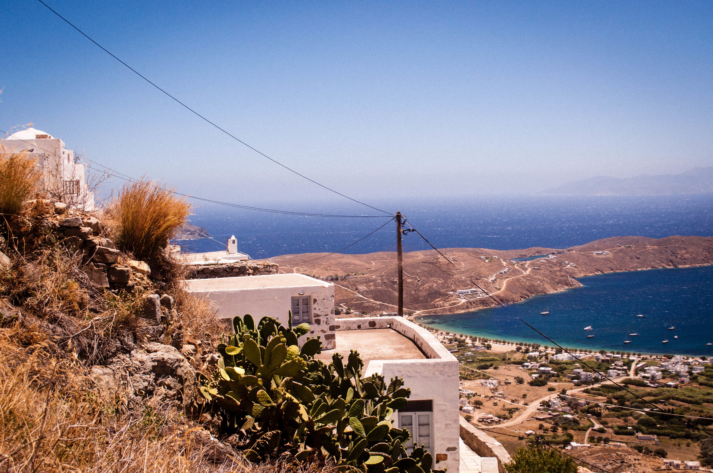 White house in Serifos’s hill overlooking the coast with the blue sea 