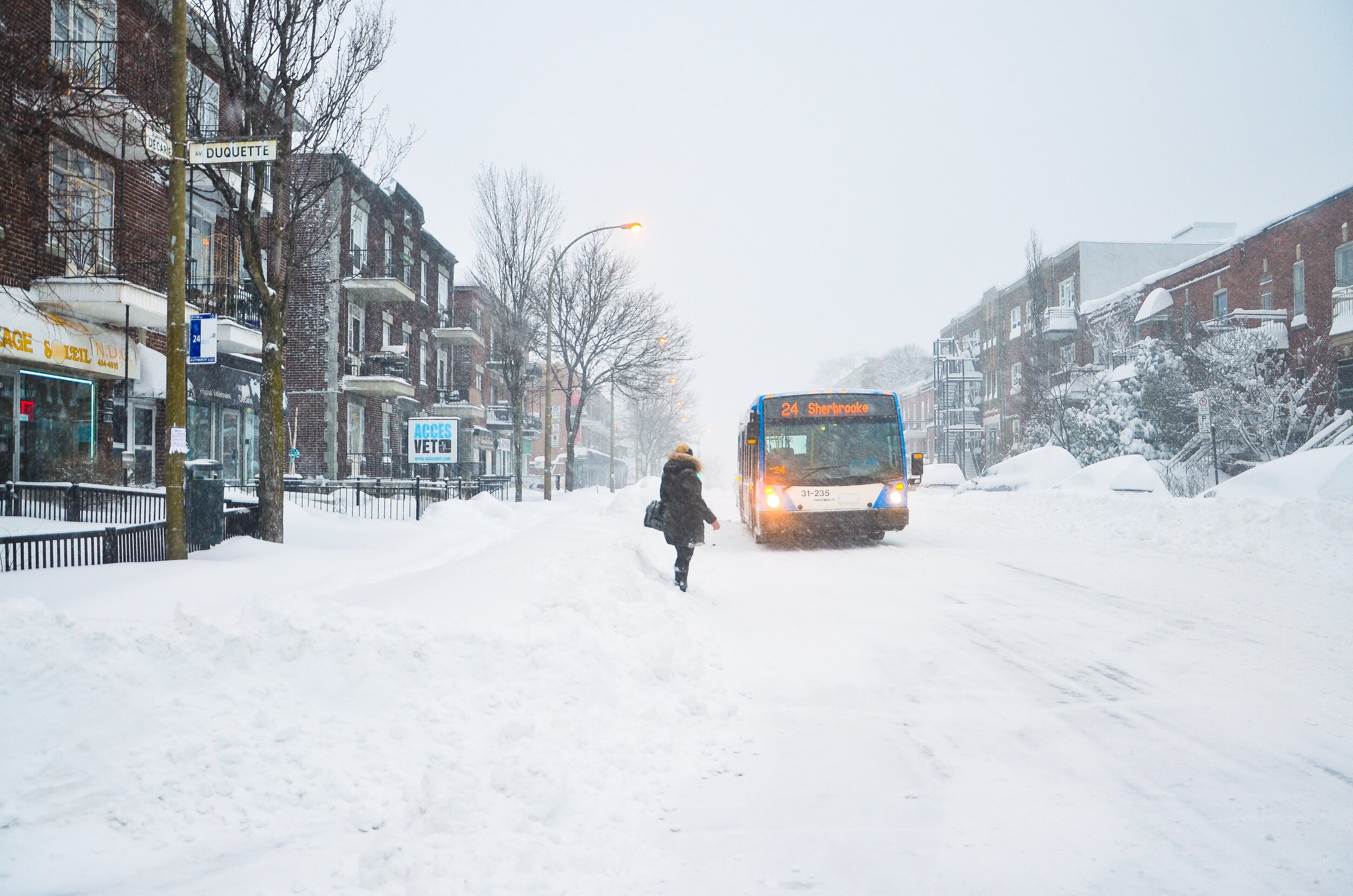 Woman waiting for her bus in a snow storm