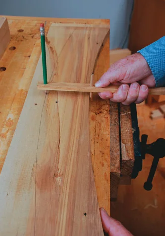 A simple jig transfers the curve to the top of the back rail