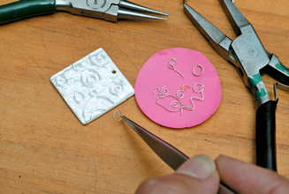 Place formed cloisonné wires on the top side. Note pendant has already been fired with clear enamel (flux). use a little gum to hold wires