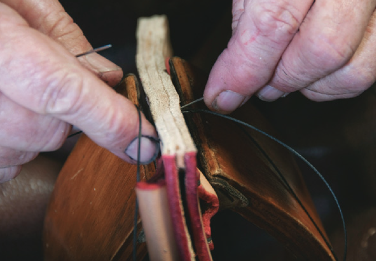 Using two needles to stitch sheath pieces and spacer held in saddler’s vice.