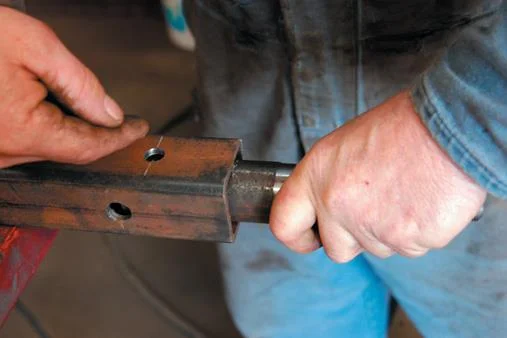 Stub axle and spring locator holes on different faces.