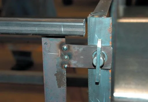 Tack weld toggle strap to hinge strap