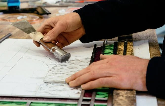 Tapping a glass piece into the lead.