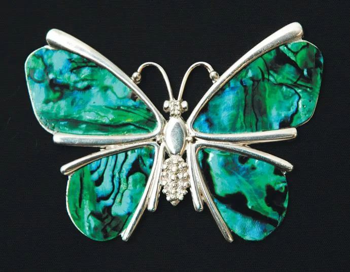 A silver butterfly takes wing