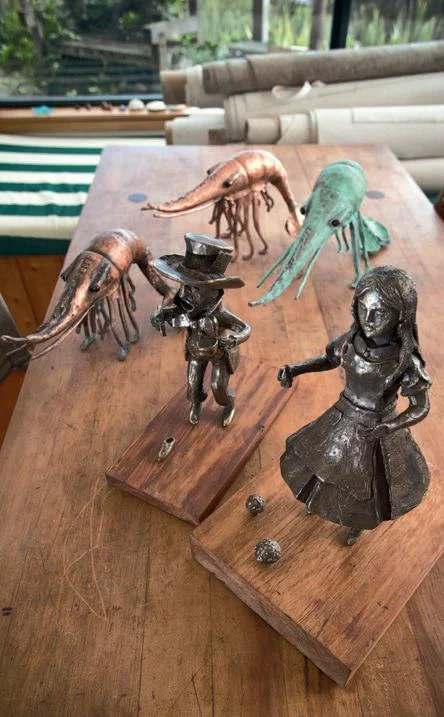 Alice and the Mad Hatter with three hand-beaten copper shrimps in the background