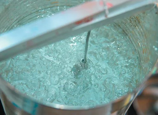 Hang spoon in boiling water to seal the oxide.