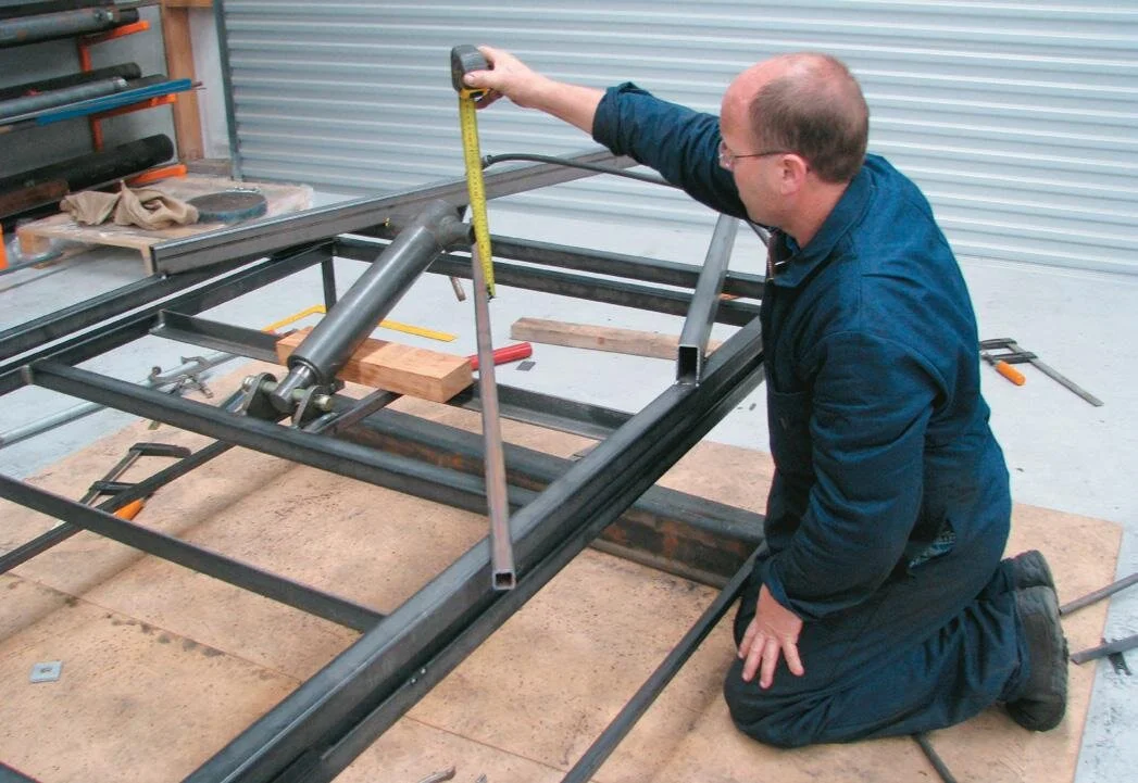 Use a block of wood to wedge the ram to the required position for the bottom mounts and ﬁt the saddles and bolt them to the hangers