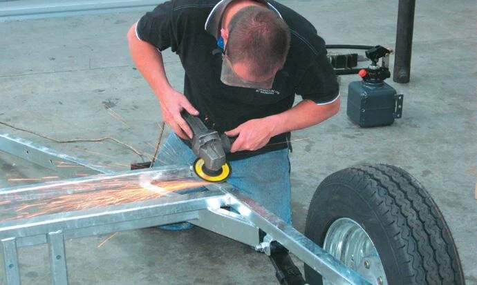 Grind off a small amount of galvanising prior to welding on the rubber blocks