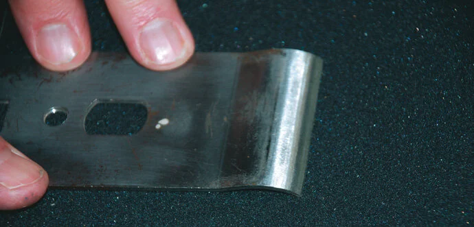 Run chip breaker across wet and dry sandpaper to ensure its ﬂatness