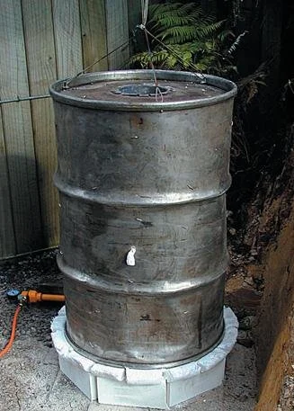 Kiln down almost ready for ﬁring (thermocouple yet to be inserted). Suspending wires are ﬁxed to the rim shackles. Note drum lining overlap at the bottom.