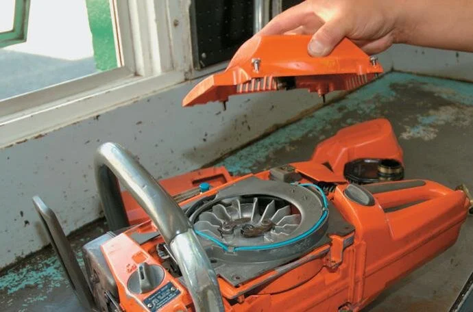 Removing the side cover to expose the ﬂywheel and coil