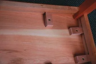 Finger clamps or buttons hold the table top on