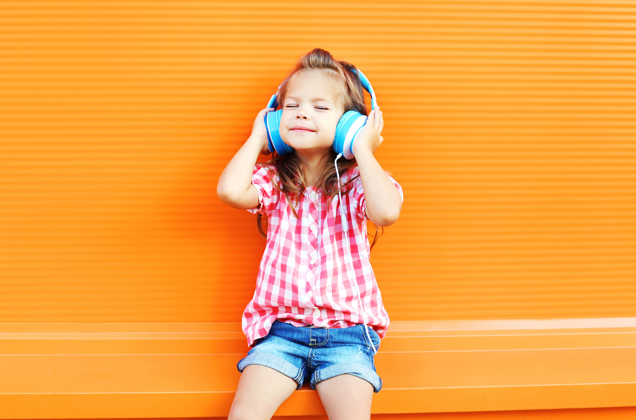 Child wearing headphones and enjoying music, reflecting creativity, joy, and balanced childhood development