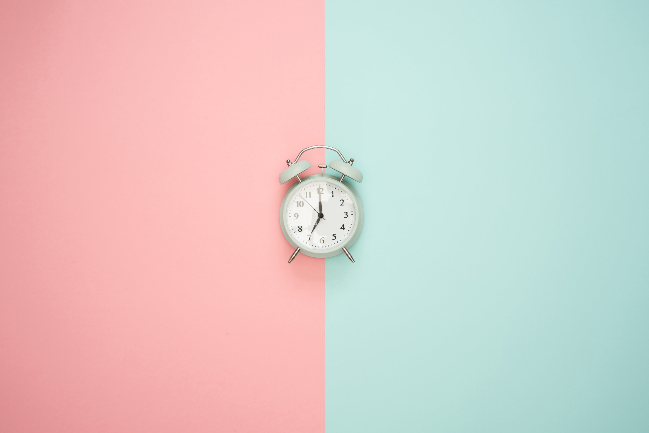 Clock centered between two colored backgrounds, representing time management and part-time childcare solutions