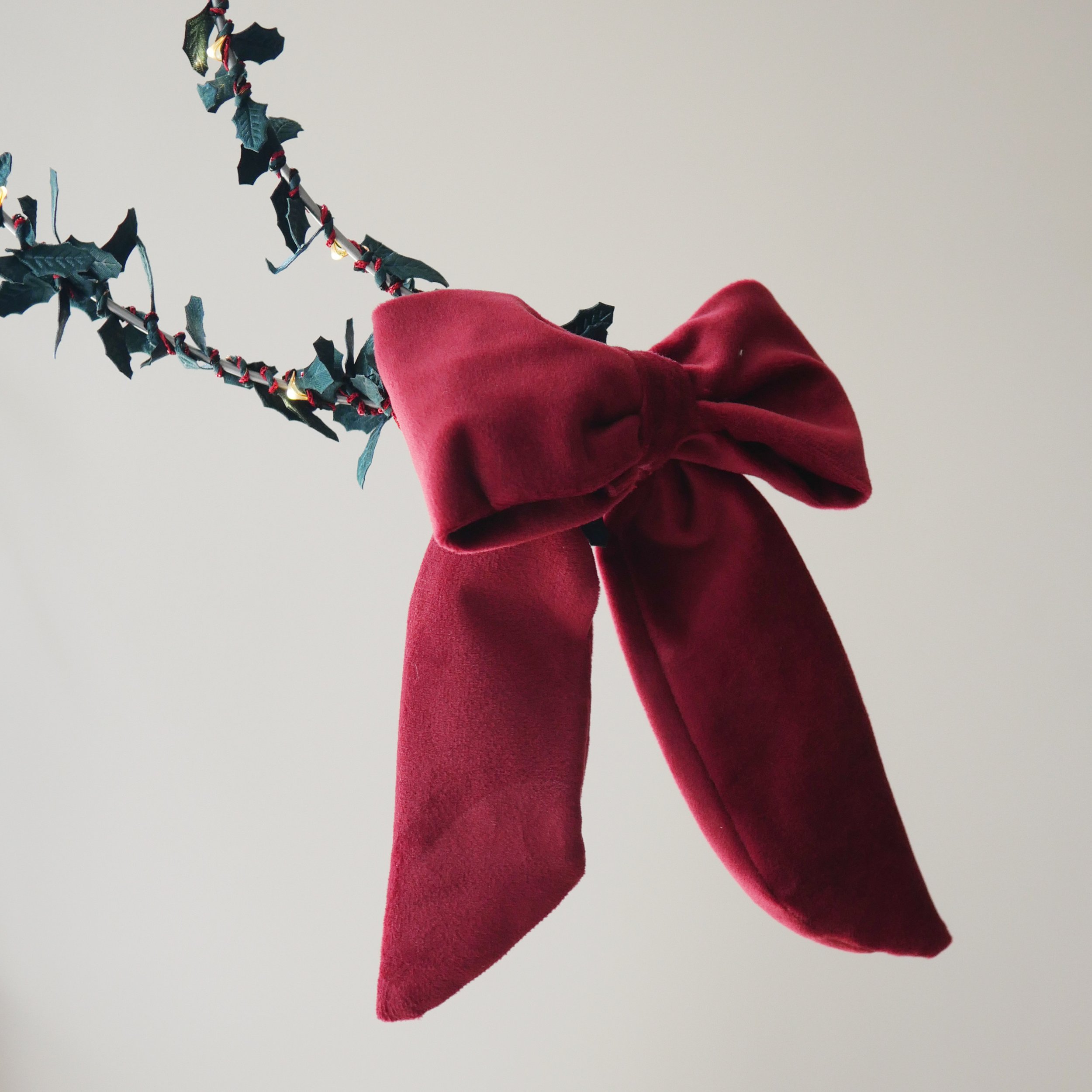Red velvet battery pack cover bow styled with Christmas holly fairy lights