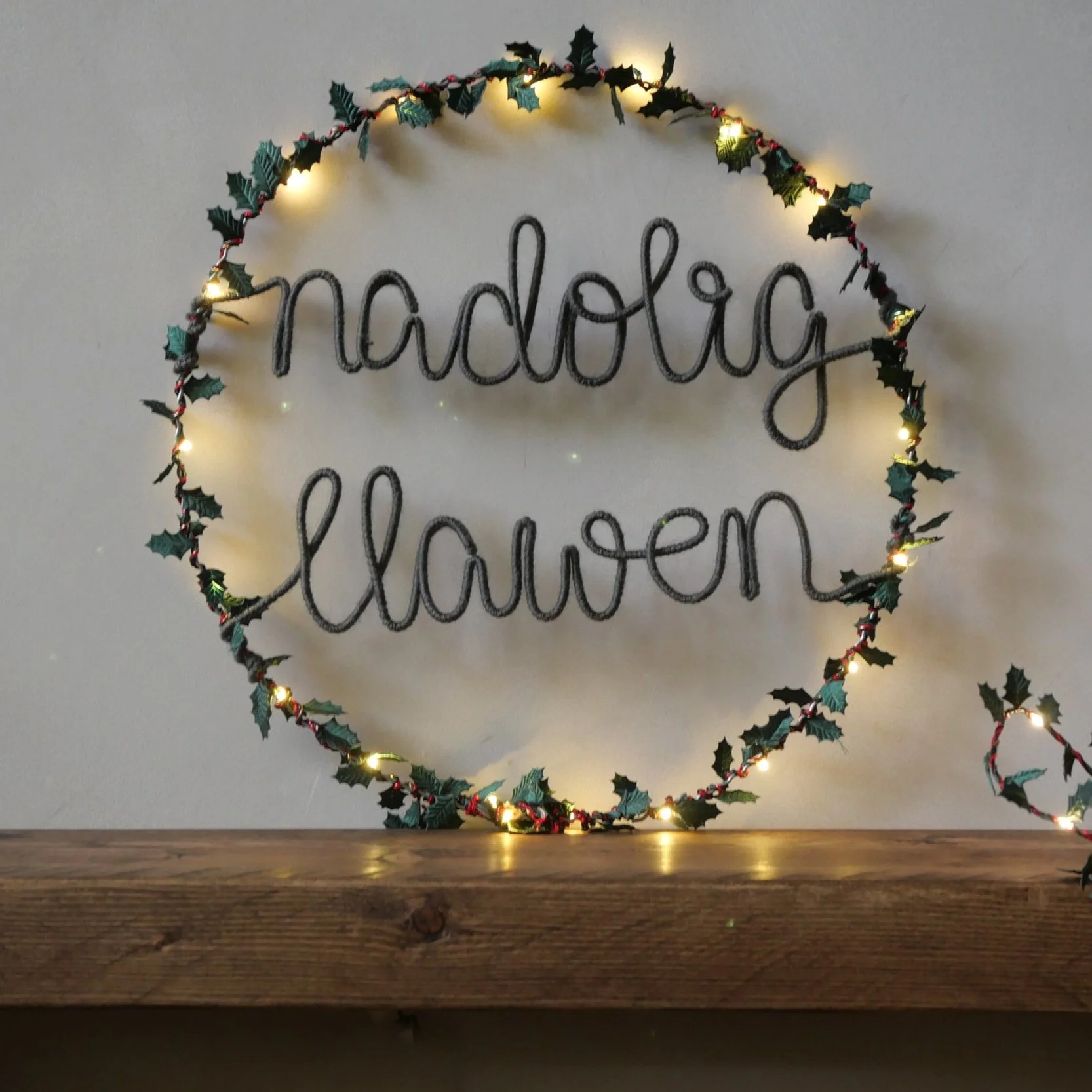 Nadolig Llawen Christmas wreath with warm grey lettering and holly leaves