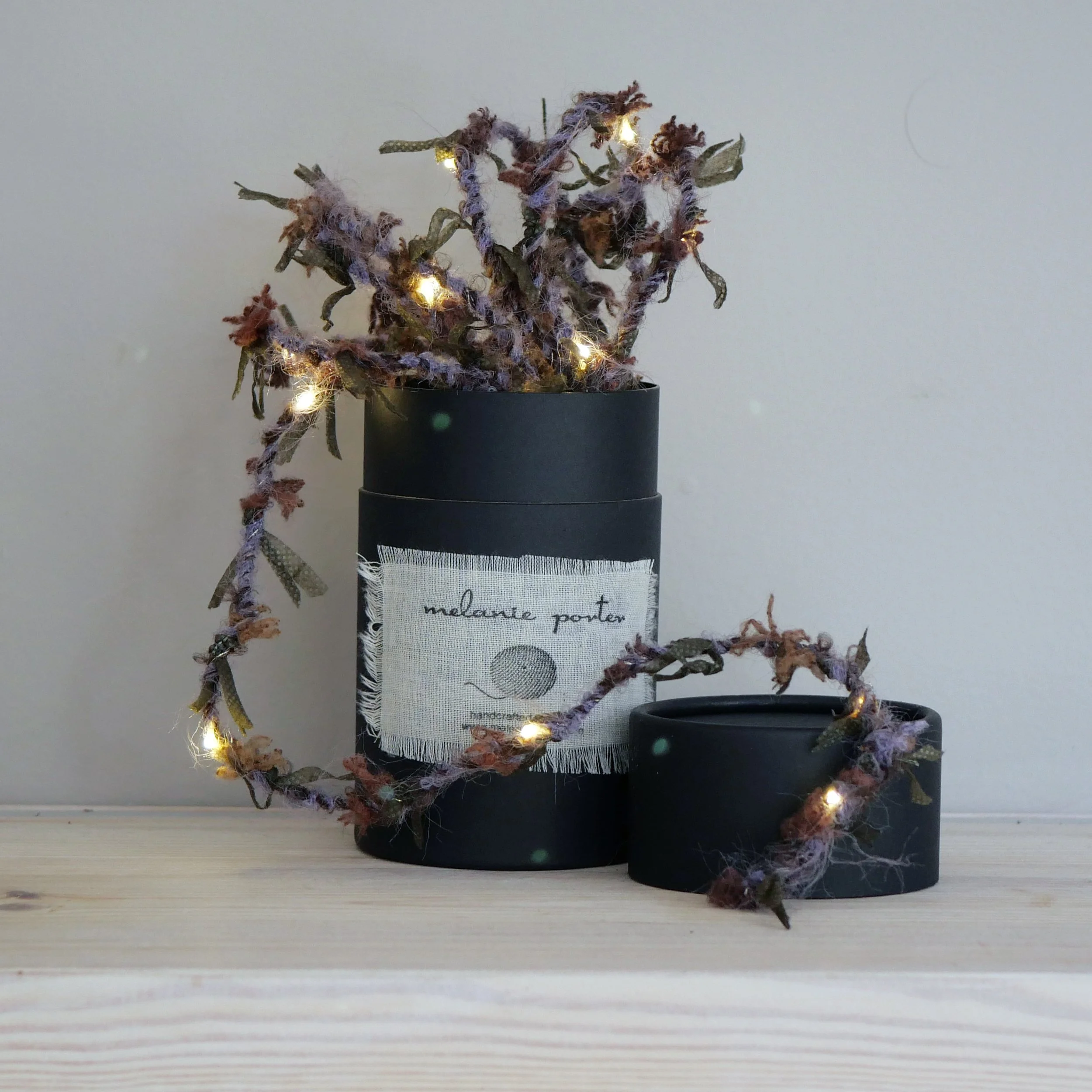 Heather Hedgerow Fairy Lights displayed around a Melanie Porter gift box
