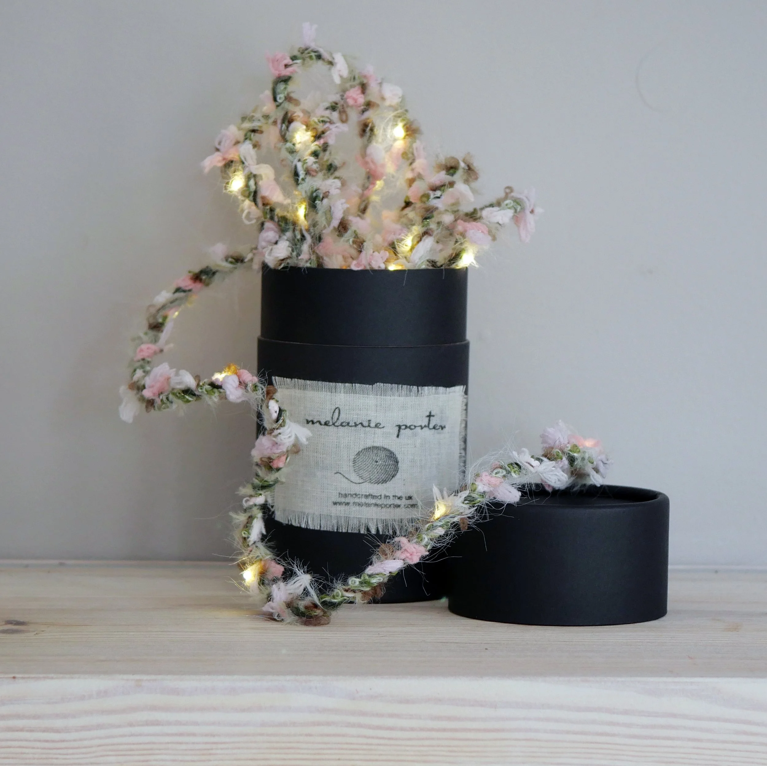 Wild Rose Hedgerow Fairy Lights displayed around a Melanie Porter gift box