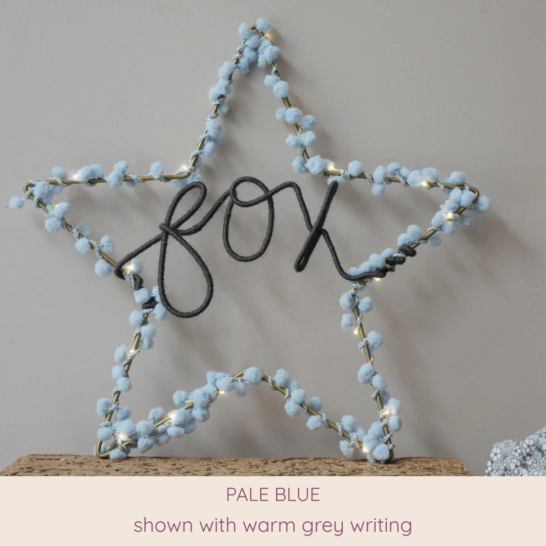Pale blue personalised star light with custom name in warm grey
