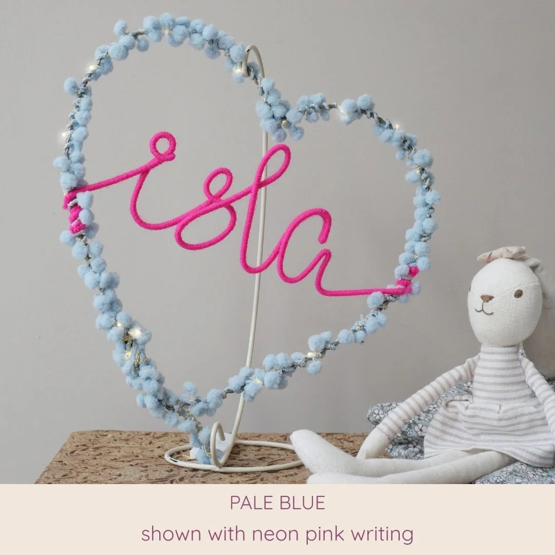 Pale blue personalised heart light with Isla name in neon pink